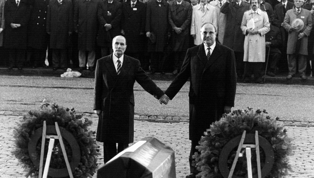 François Mitterrand and Helmut Kohl holding hands at a memorial ceremony